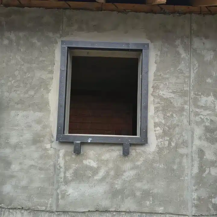 Cadru de montaj pentru fereastră instalat pe un perete exterior tencuit.