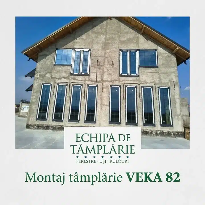 Fațadă de casă în construcție cu ferestre termopan de culoare închisă montate.